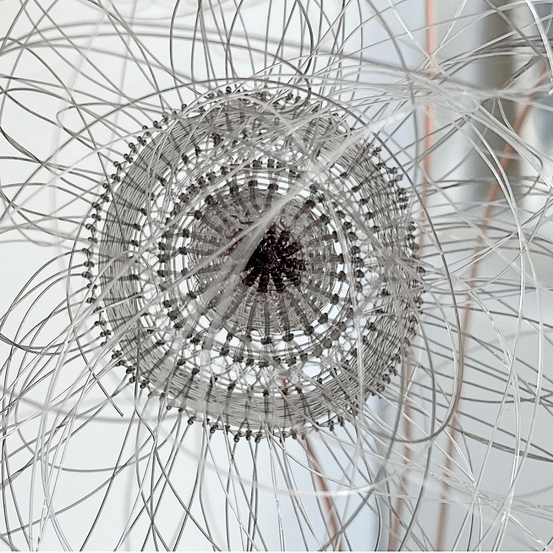 Woven flower by Lucy Sugden using grey fishing line.